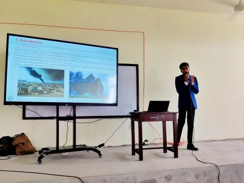 Md Sabbir Islam presenting a paper beside a screen showing the introduction slide