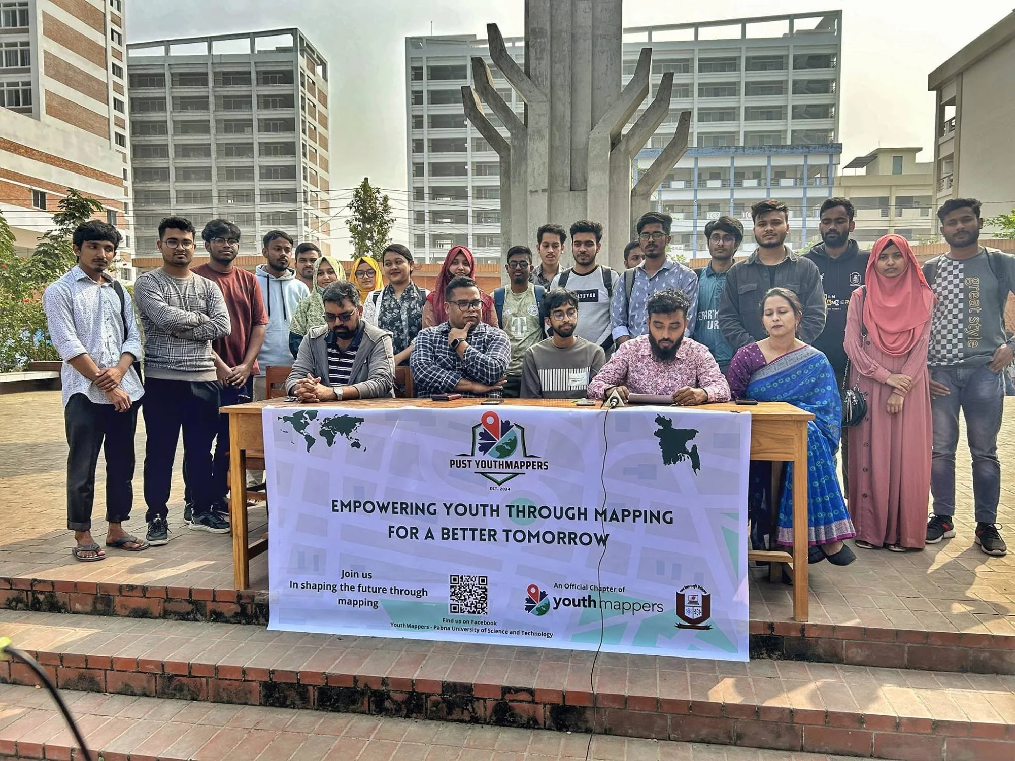 Students and teachers of PUST YouthMappers gathered behind a banner on the university campus